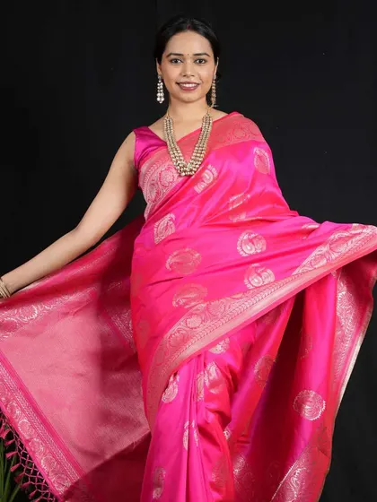 A multi-layered pearl and bead necklace adds a touch of grandeur to this model's bright pink Banarasi saree.