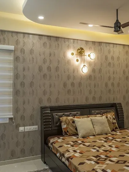 A consistent theme of warmth is carried through this bedroom with its color palette and lighting choices.