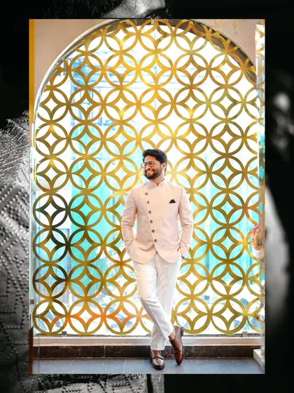 A stylish groom posing against a beautifully designed gold latticework window. We always look for unique spots at the venue for creative portraits.