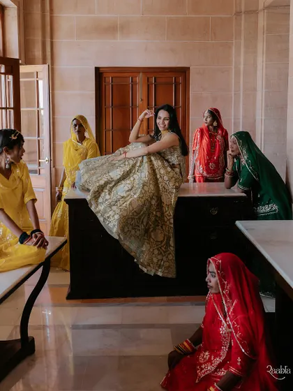 The bride sharing a candid moment with local women, a beautiful interaction captured during her Mehendi ceremony at the palace.