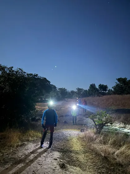 Hiking with headlamps under a starry sky on the way to Ratangad. The pre-dawn hours on the trail are quiet, cool, and magical.