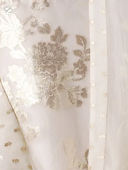 A close-up of the glimmering Swarovski crystals and delicate 3D accents on a white Onam lehenga, perfect for celebrating new beginnings.