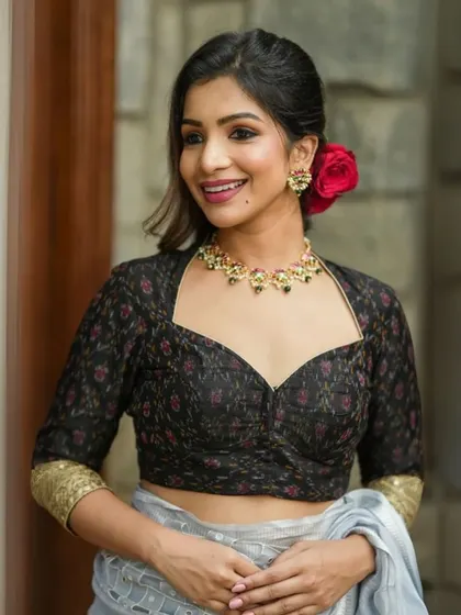A black printed blouse with a sweetheart neckline is accessorized with a matching black stone choker.