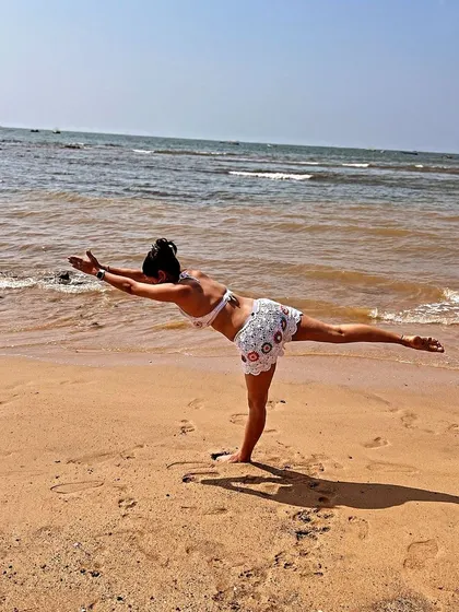 Flying into Virabhadrasana III, or Warrior III, with the ocean breeze supporting me. This pose strengthens the entire back of the body and builds focus, creating a feeling of soaring above the waves.