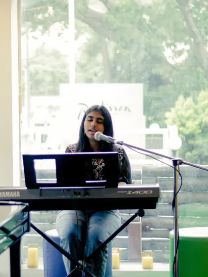 A student singing and playing the keyboard at a recital. We encourage our students to become multi-talented musicians.
