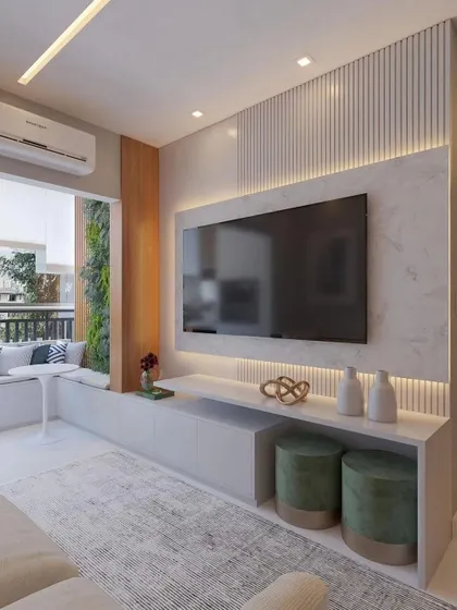 A minimalist TV unit design featuring a floating console, fluted wall panels, and subtle backlighting. The adjoining balcony seating nook extends the living space.