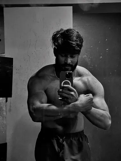 "Born to express, not to impress." A black and white photo flexing the bicep, focusing on the art of the physique.