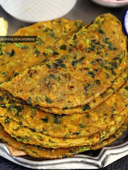 A stack of our healthy and flavorful Methi Parathas. These flatbreads are infused with fresh fenugreek leaves and spices, served with a side of butter and yogurt.