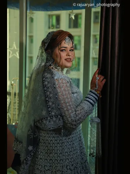 A beautiful portrait of the bride by a window, using natural light to create a soft and dreamy effect. Her glance over the shoulder adds a touch of cinematic flair.