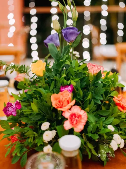 A colorful floral centerpiece with a mix of roses and other blooms, adding a pop of color to the reception tables.
