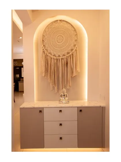 A beautiful foyer console with an arched niche featuring a macrame dream catcher. The design is simple, serene, and creates a welcoming ambiance.