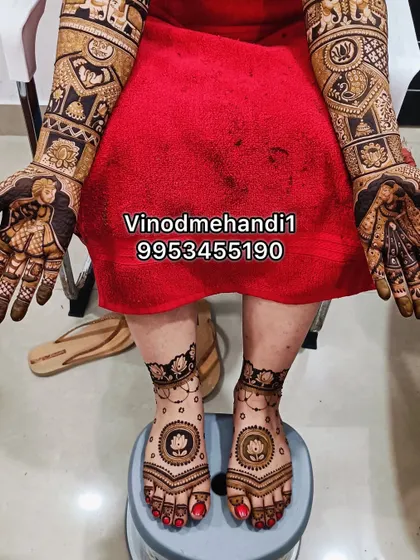 This photo captures the complete bridal mehendi, with detailed portraits on the hands and matching lotus designs on the feet for a harmonious look.