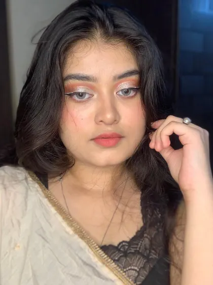 A soft glam look with silver glitter eyeshadow and a white winged liner accent.
