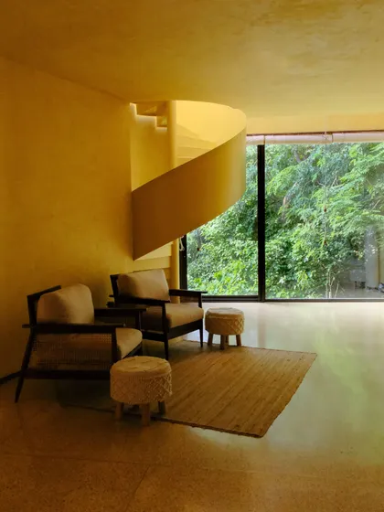The Banyan Suite's living area, showcasing the blend of modern furniture, natural light, and unique architectural details.