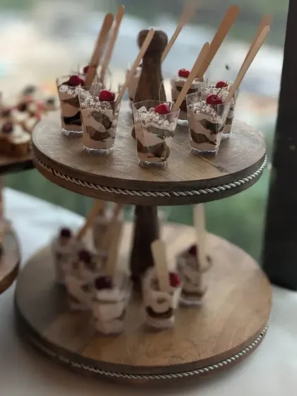 My Tiramisu cups served on a two-tiered wooden stand. This is a great way to serve individual desserts at larger gatherings, ensuring easy access for guests.