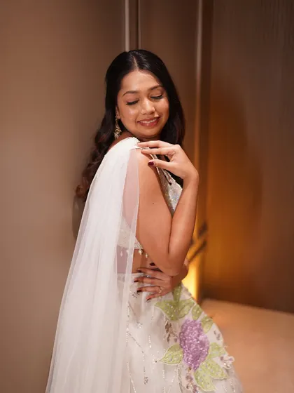 A side view showing the delicate draping of the dupatta and the soft waves in her hair.