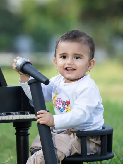 A happy moment from the outdoor music session, with the little one smiling brightly.