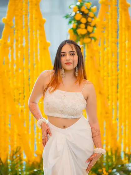 A confident front-facing pose in the white Haldi outfit. This shot clearly shows the delicate top and modern draped skirt.