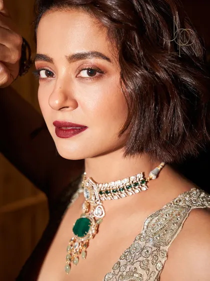 An intimate portrait of Surveen Chawla, her eyes and the emerald in her necklace sharing the same intensity.