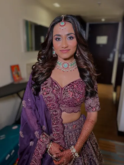 A full view of the bride in her purple lehenga, looking happy and confident. My rental service is all about making your day special.