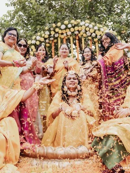 The bride surrounded by her family as they shower her with flowers. A heartwarming moment of love and celebration.