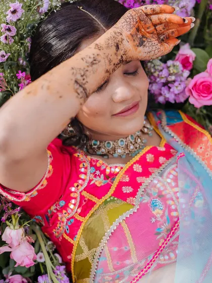 A creative portrait of the bride lying in a bed of flowers, a dreamy and artistic shot.