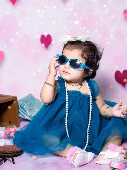 This little fashionista is striking a pose with her sunglasses. My studio shoots are all about letting your child's personality shine through.