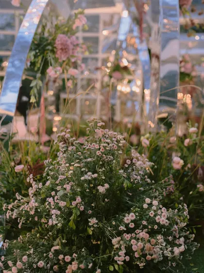 A close-up of the dreamy fresh florals used in the mirrored arch mandap. The soft textures and colors of the baby's breath and other wildflowers created a delicate contrast with the modern structure.