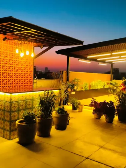 The completed bar and pergola at dusk in Palam Vihar. The warm lighting creates an inviting atmosphere for evening gatherings.