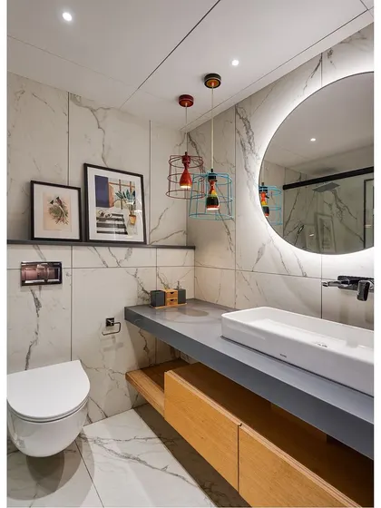 The family room bathroom is a playful space, with colorful cage-like pendant lights contrasting with the elegant marble-patterned tiles.