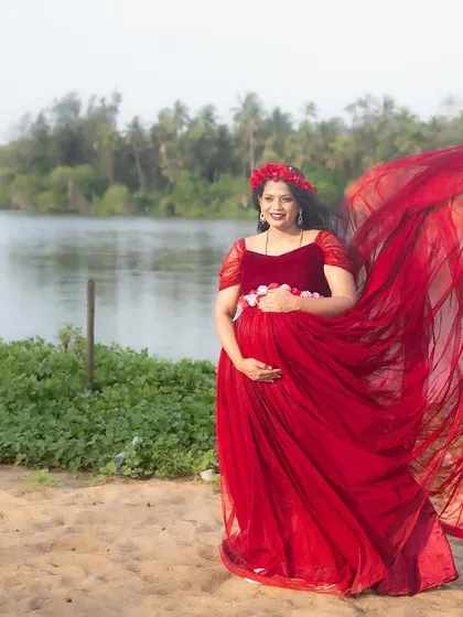 Our red maternity gown looks vibrant and beautiful against the natural backdrop of a beach or lake for your photoshoot.