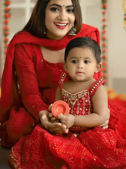 A beautiful mother-daughter portrait from our Diwali session. The mother helps her little one hold a diya, creating a special cultural memory.