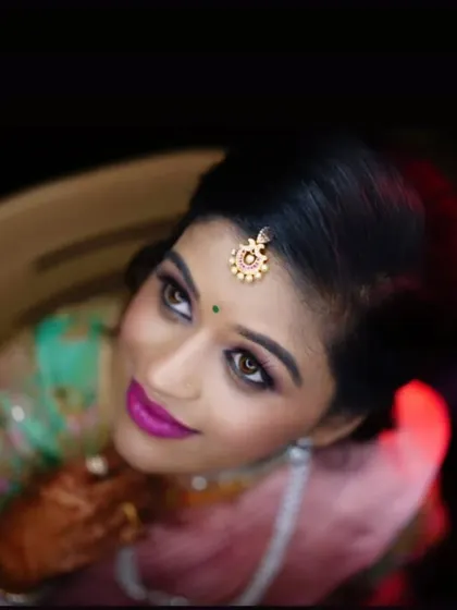 An artistic shot of a reception look, highlighting the bright pink lip and shimmery eye makeup.