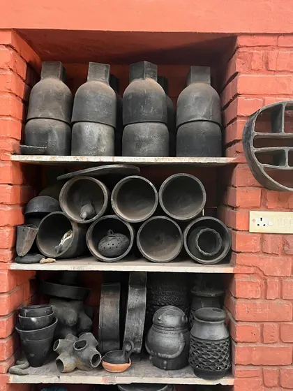 Shelves filled with handmade black pottery at a studio in Hampi. These objects represent the rich craft traditions we seek to preserve and integrate.