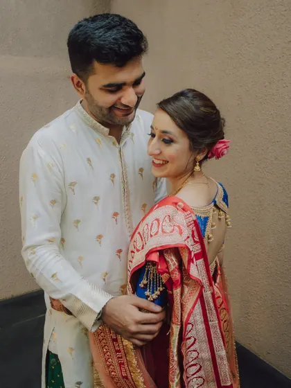 A happy, smiling portrait of a couple in traditional attire. Their genuine smiles and easy chemistry shine through in this lovely shot.