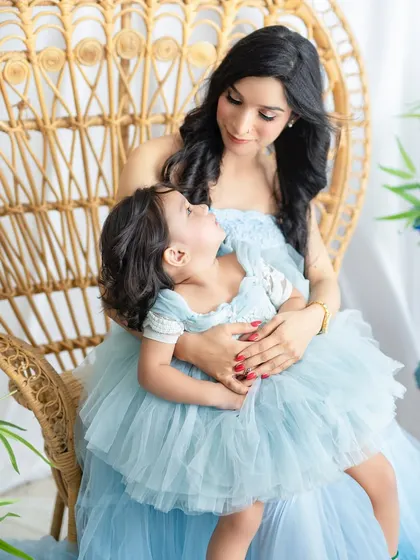 A mother and daughter share a loving gaze in a beautiful peacock chair. These mommy-and-me sessions are a wonderful way to celebrate your bond.