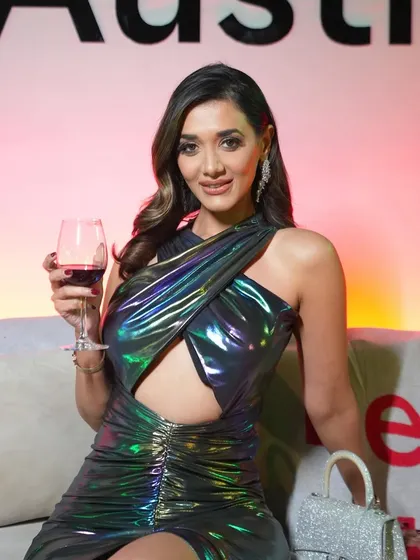 The client enjoying a glass of wine, her makeup looking flawless under the event lighting.