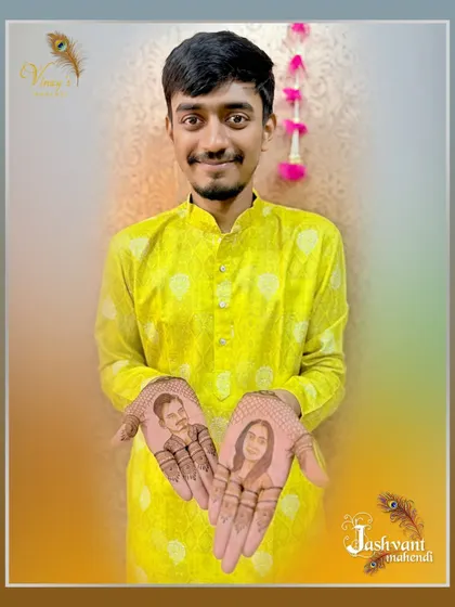 A proud groom displaying his personalized mehndi, featuring portraits of himself and his bride on each palm.