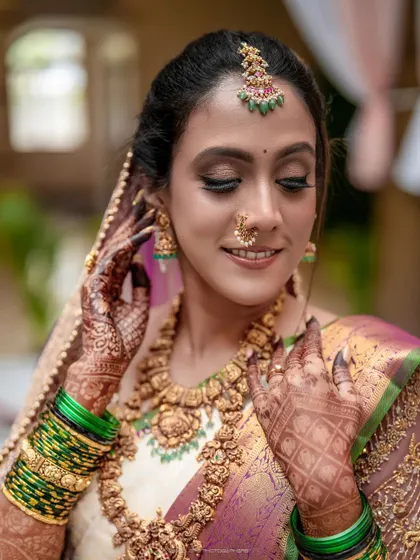 A close-up portrait of the bride, highlighting her intricate henna, stunning jewelry, and flawless makeup. Every detail contributes to her breathtaking look.
