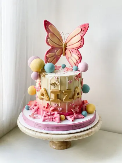 The prettiest butterfly themed cake, with a large statement butterfly topper and a cascade of smaller butterflies and bows.