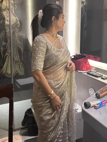 Sahana looks absolutely gorgeous in this organza saree. I designed the blouse with delicate beadwork and sheer sleeves for an elegant, understated look perfect for an evening event.