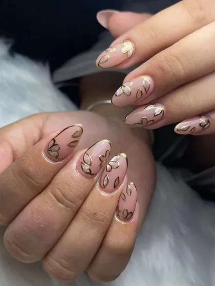 A full set of nude nails with gold floral outline art. This minimalist yet detailed design is very popular and chic.