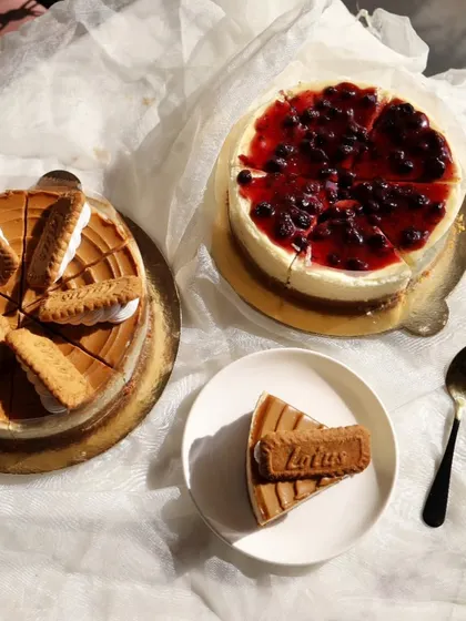 A look at two of our most popular baked cheesecakes. On the left is the indulgent Lotus Biscoff cheesecake, and on the right is our classic, creamy Blueberry cheesecake with a rich fruit topping.