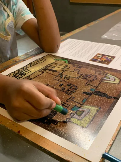 A close-up of a student coloring in their Picasso-inspired drawing, learning about shape and composition.