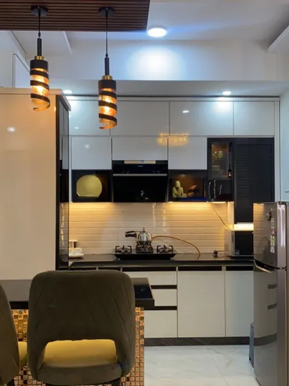 This kitchen includes a compact breakfast counter, perfect for small families or quick meals. The design is integrated with a tall display unit, making it both stylish and functional.