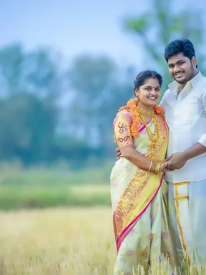 A classic post-wedding portrait of the couple. This shot captures their happiness and the traditional beauty of their outfits against a serene, natural backdrop.