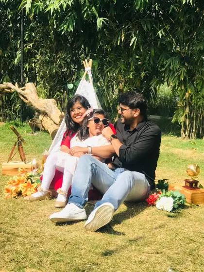 A candid moment of a father and his daughters enjoying their time together at their family picnic.