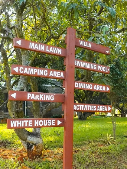 It's easy for groups to find their way around the resort with clear signage. This post points towards key locations like the Main Lawn, Camping Area, Swimming Pool, and the Activities Area, helping to keep the day organized and flowing smoothly.