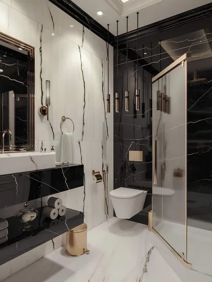 I transform bathrooms into personal spas with bold materials and thoughtful layouts. This design uses dramatic black and white marble with gold fixtures, a floating toilet, and a glass shower enclosure for a clean, high-end finish.