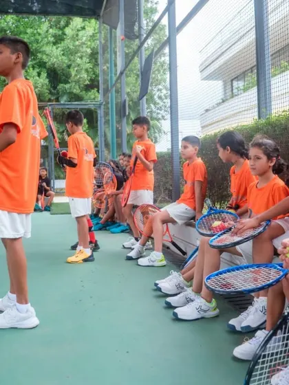 Our young players listen attentively during a group session. We foster an environment of focus and discipline, balanced with fun and encouragement, to help them absorb new skills and strategies.